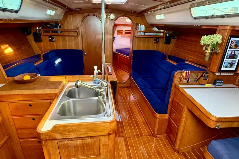 Slide: The Image of Luxurious 1991 J/Boats yacht interior with wood finish, blue seating, and modern amenities. - 1