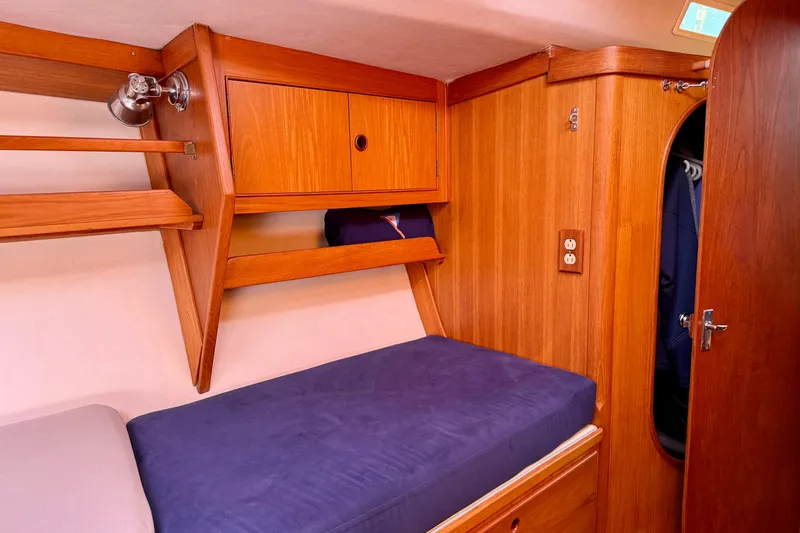 Slide: The Image of Cozy wooden cabin interior of a 1991 J/Boats model with blue bedding. - 12