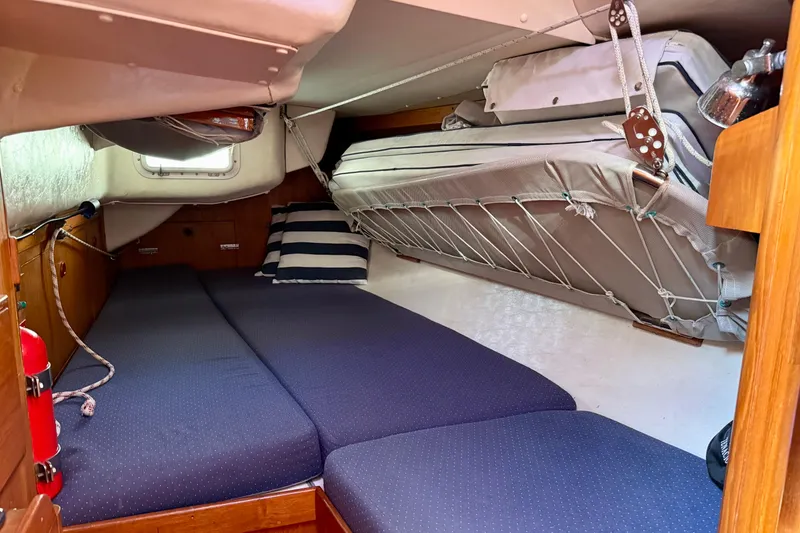 Slide: The Image of Cozy cabin interior of a 1991 J/Boats model with blue bedding and striped pillows. - 14