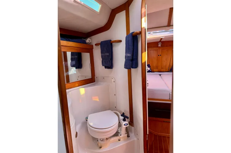 Slide: The Image of Bathroom interior of a 1991 J/Boats model, featuring wooden accents and nautical decor. - 15