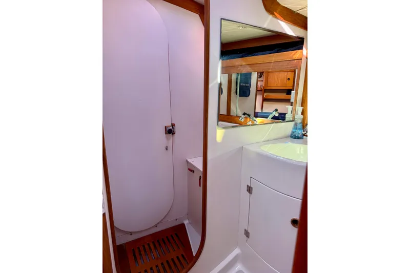 Slide: The Image of Interior of 1991 J/Boats yacht bathroom with sink, mirror, and wooden accents. - 18