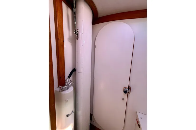 Slide: The Image of Interior of 1991 J/Boats model, featuring a compact bathroom with wooden accents. - 20