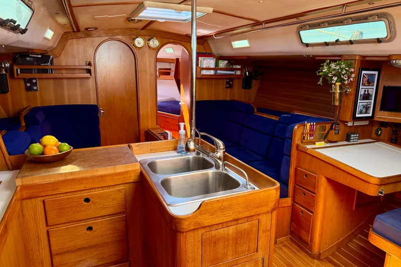 Slide: The Image of Luxurious 1991 J/Boats yacht interior with wooden cabinetry and blue seating. - 23