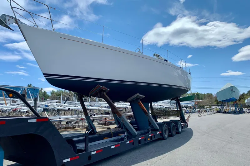 Slide: The Image of Sailboat on trailer, J/Boats J/47, 1991 model, in a boatyard under blue sky. - 26