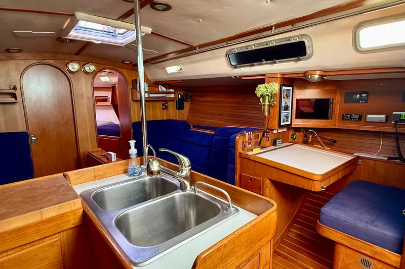Slide: The Image of Interior of a 1991 J/Boats yacht with wooden finish, kitchenette, and seating area. - 5