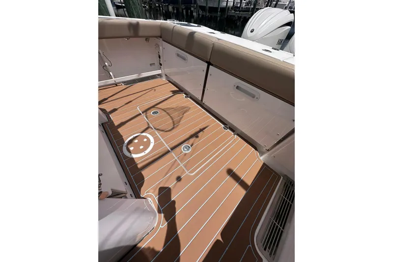 Slide: The Image of 2023 Everglades 285 Center Console boat deck with tan seating and wood-style flooring. - 10