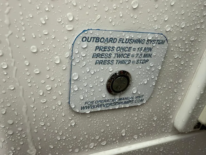 Slide: The Image of 2023 Everglades 285 Center Console outboard flushing system button with water droplets. - 13