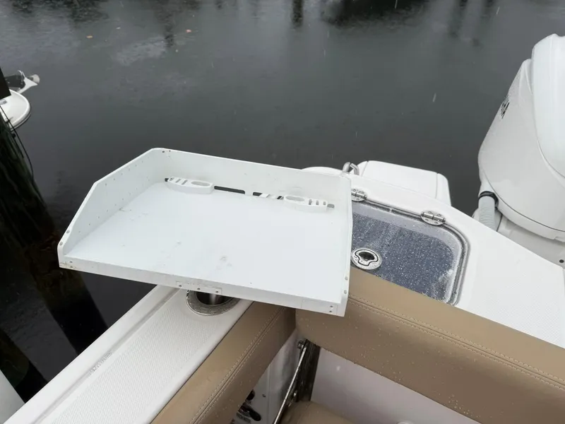 Slide: The Image of 2023 Everglades 285 Center Console boat with a white accessory tray and beige seating. - 16