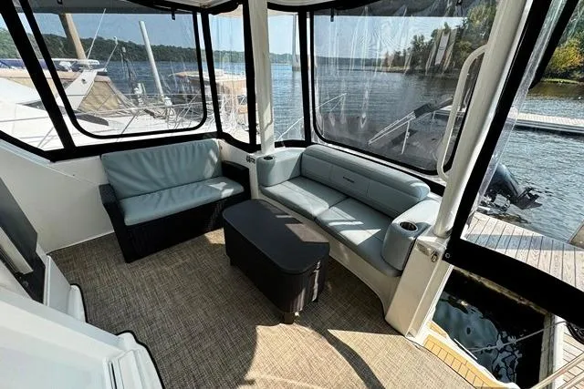 Slide: The Image of 2004 Silverton 35 MY Aft Cabin Motoryacht interior with seating, docked by a scenic lake. - 28