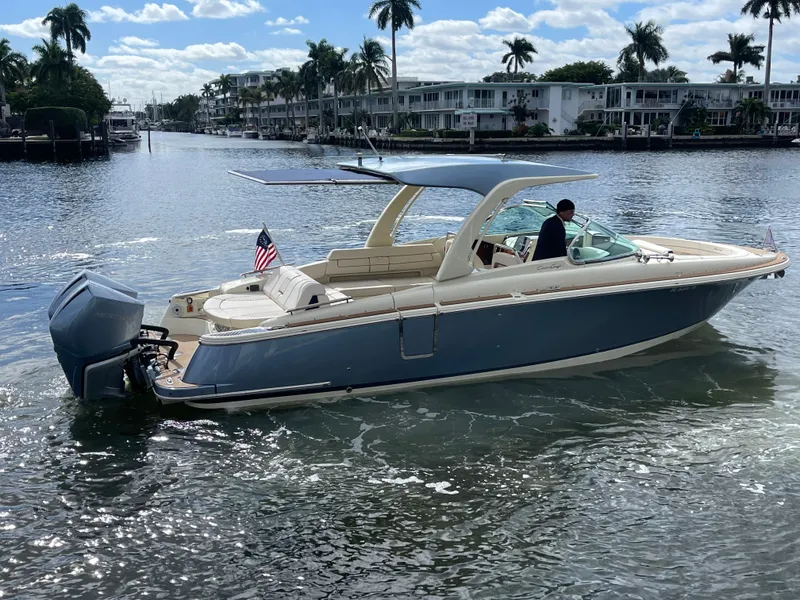 Slide: The Image of 2023 Chris-Craft Launch 31 GT boat cruising on a sunny waterfront. - 2