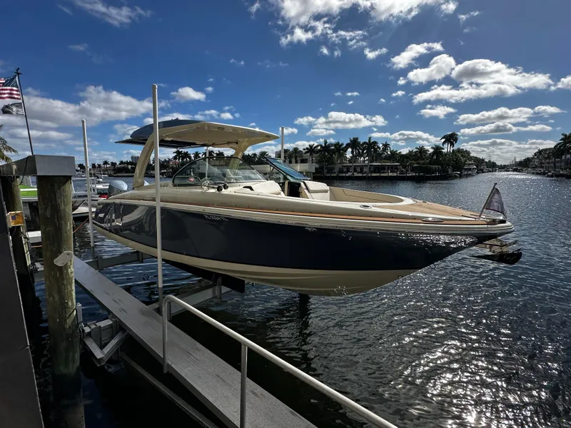 Slide: The Image of 2023 Chris-Craft Launch 31 GT boat docked on a sunny waterfront. - 4