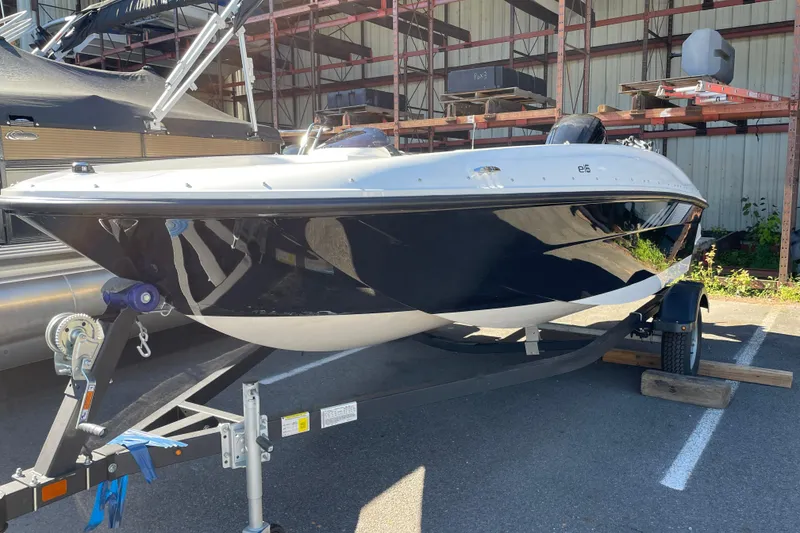 Slide: The Image of 2026 Bayliner Element E16 boat on trailer in outdoor storage area. - 2