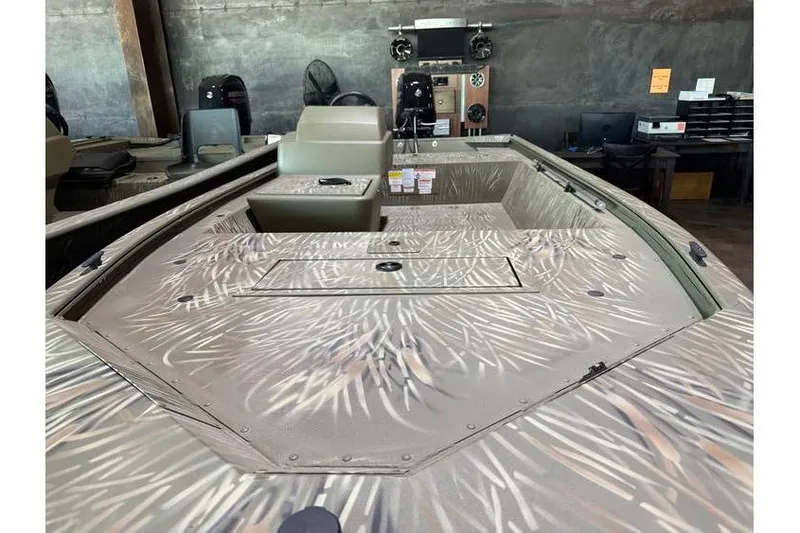 Slide: The Image of 2024 Tracker Grizzly 1648 boat with camouflage design in showroom setting. - 10