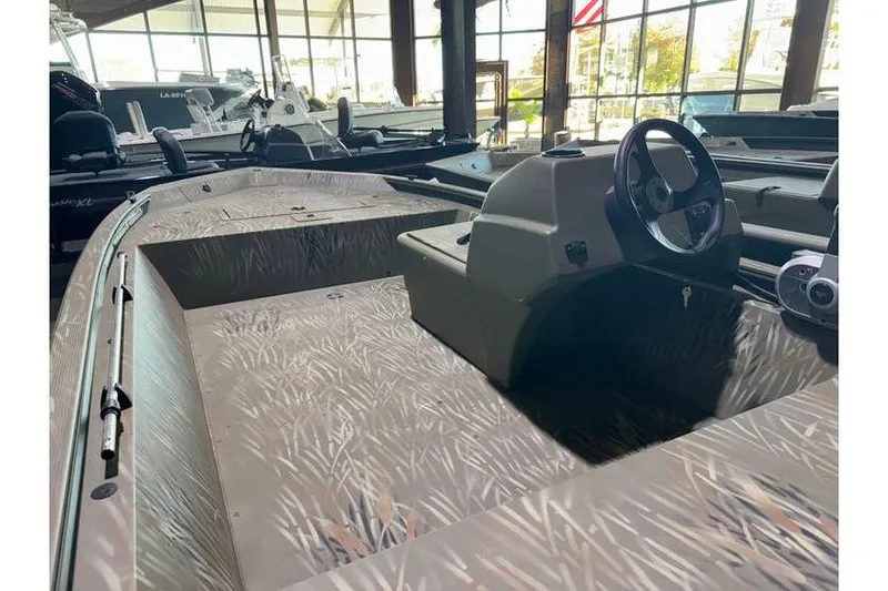 Slide: The Image of 2024 Tracker Grizzly 1648 boat interior with camouflage design, steering console, and spacious layout. - 8