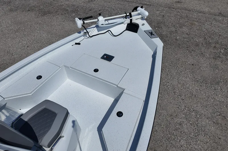 Slide: The Image of 2026 Xpress H20 boat deck with seating and trolling motor, parked on concrete surface. - 10