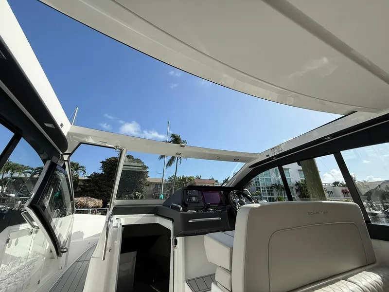 Slide: The Image of Interior view of 2025 Schaefer 375 yacht, showcasing helm and seating under clear blue sky. - 12