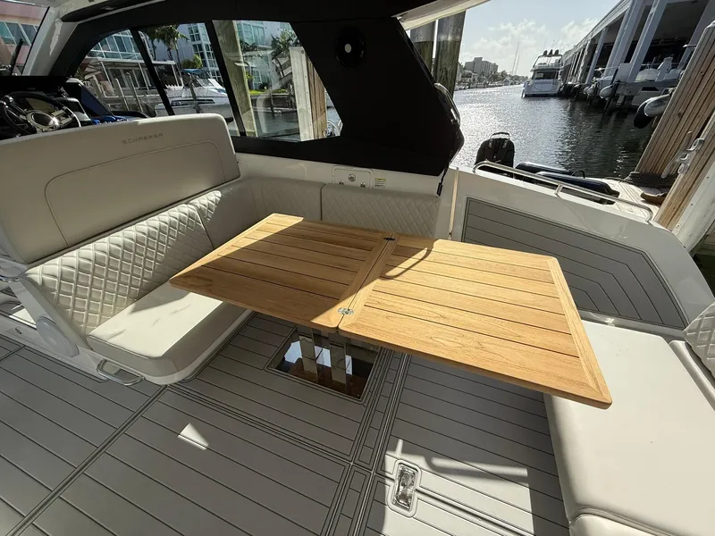 Slide: The Image of Luxurious 2025 Schaefer 375 yacht interior with elegant seating and wooden table by the water. - 17