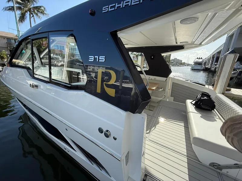 Slide: The Image of 2025 Schaefer 375 yacht docked, featuring sleek design and spacious seating area. - 18