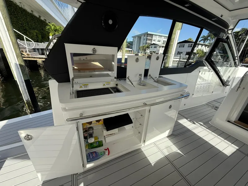 Slide: The Image of Luxury yacht Schaefer 375 (2025) with outdoor kitchen and storage, docked by waterfront. - 23