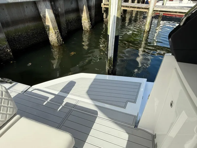 Slide: The Image of Schaefer 375 yacht deck near dock, showcasing sleek design and water reflections, 2025 model. - 25
