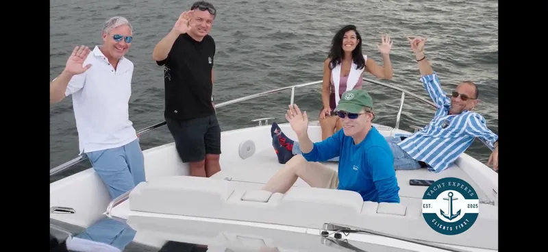 Slide: The Image of Group enjoying on a 2025 Schaefer 375 yacht, waving and smiling on the water. - 6