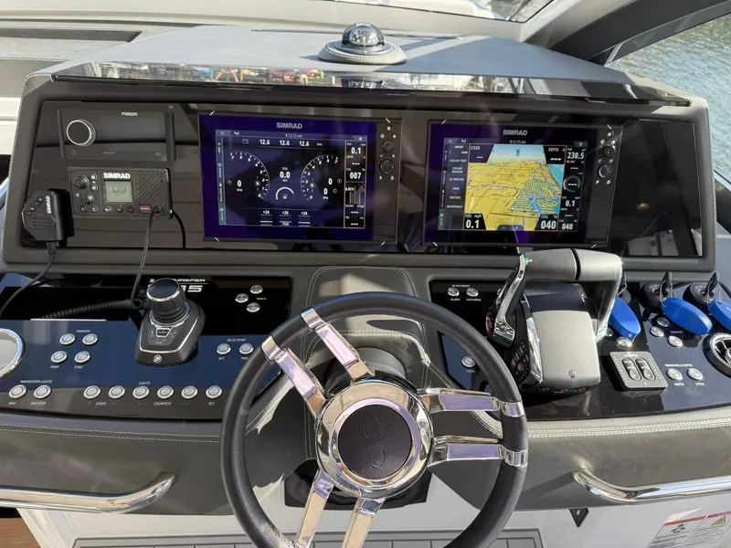 Slide: The Image of Control panel of 2025 Schaefer 375 yacht with advanced navigation displays and steering wheel. - 8