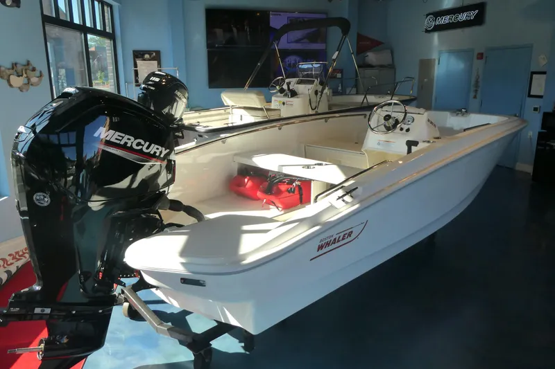 Slide: The Image of 2025 Boston Whaler 160 Super Sport boat with Mercury engine in showroom. - 2