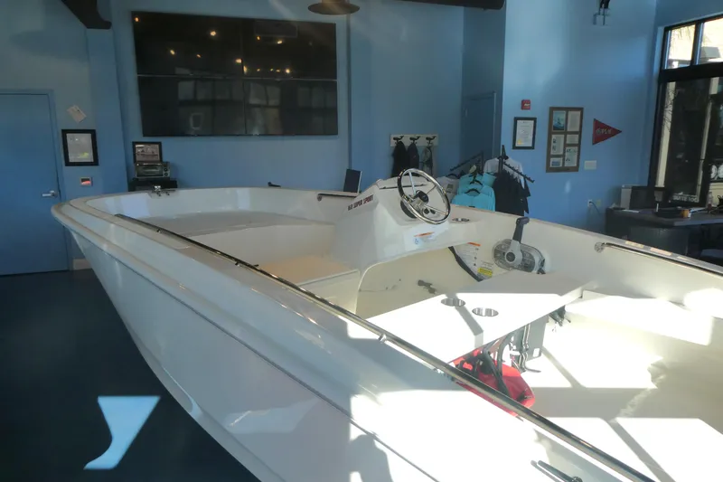 Slide: The Image of 2025 Boston Whaler 160 Super Sport boat displayed in a showroom with blue walls. - 5