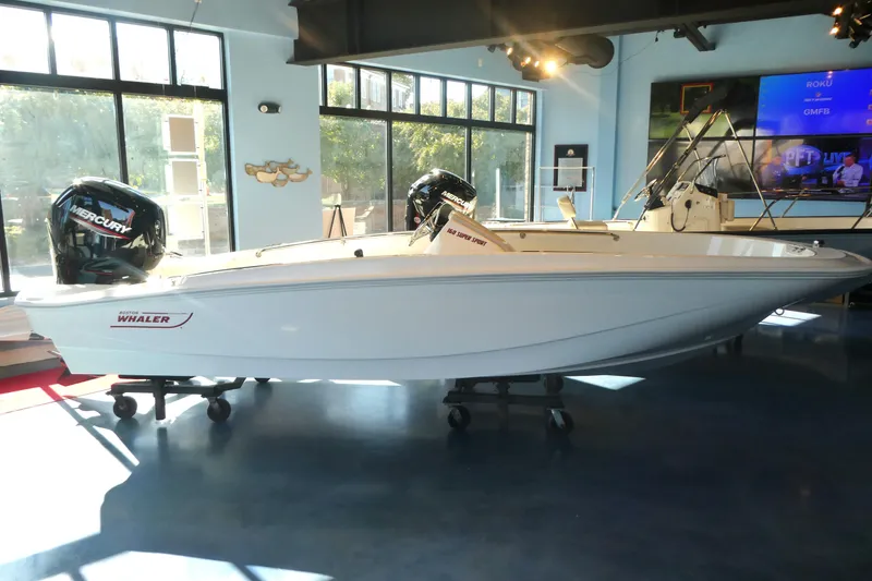 Slide: The Image of 2025 Boston Whaler 160 Super Sport boat displayed indoors with Mercury engines. - 6