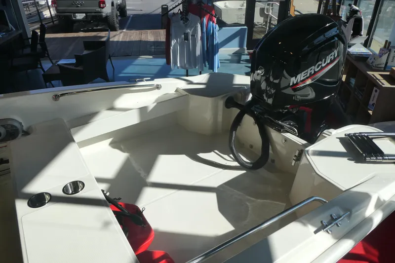 Slide: The Image of 2025 Boston Whaler 160 Super Sport boat interior with Mercury engine in showroom. - 7