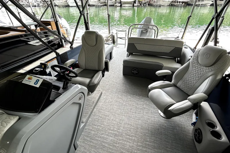 Slide: The Image of 2025 Godfrey Monaco 255 DFL pontoon boat docked, featuring spacious seating and modern design. - 10