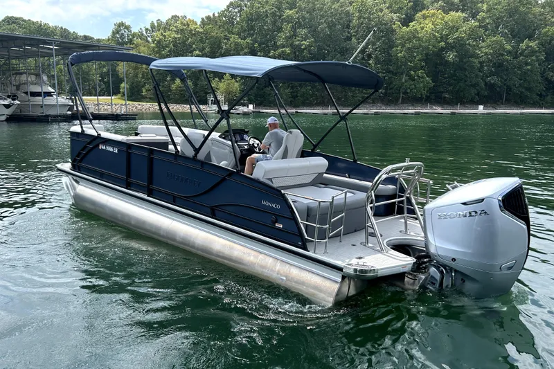 Slide: The Image of 2025 Godfrey Monaco 255 DFL pontoon boat on a lake with Honda outboard motor. - 2