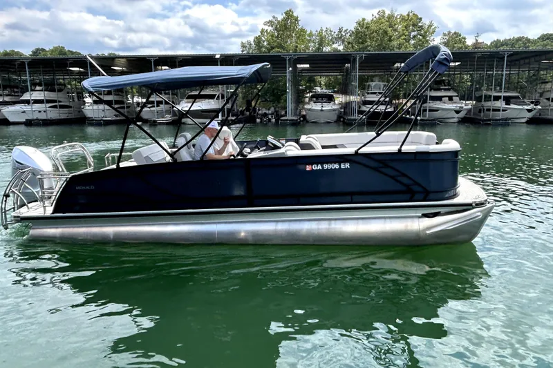 Slide: The Image of 2025 Godfrey Monaco 255 DFL pontoon boat on a serene lake. - 5