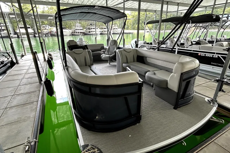 Slide: The Image of 2025 Godfrey Monaco 255 DFL pontoon boat with luxurious seating at a marina. - 8