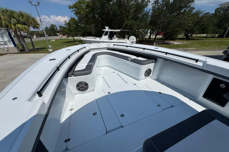 Slide: The Image of 2026 Yellowfin 39 Offshore boat interior with seating and speakers, docked outdoors. - 24