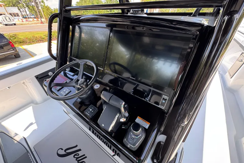 Slide: The Image of 2026 Yellowfin 39 Offshore boat dashboard with steering wheel and navigation screens. - 37