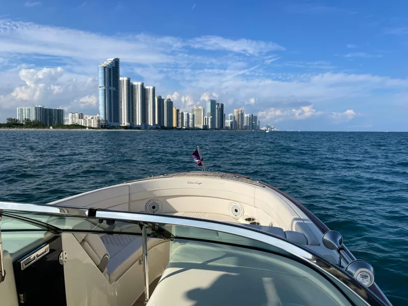 Slide: The Image of Chris-Craft 28 Launch GT 2021 boat cruising near a city skyline. - 6