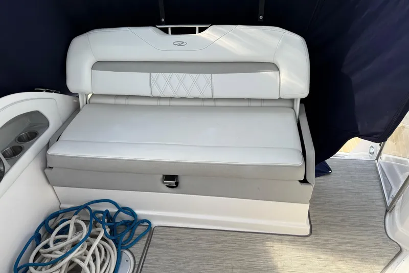 Slide: The Image of 2019 Regal 28 Express boat interior with white cushioned seating and coiled ropes. - 16