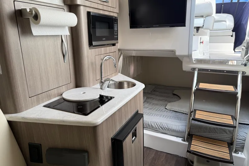 Slide: The Image of Interior of 2019 Regal 28 Express boat with kitchenette and sleeping area. - 20