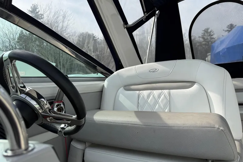 Slide: The Image of Interior of a 2019 Regal 28 Express boat with steering wheel and white seating. - 24