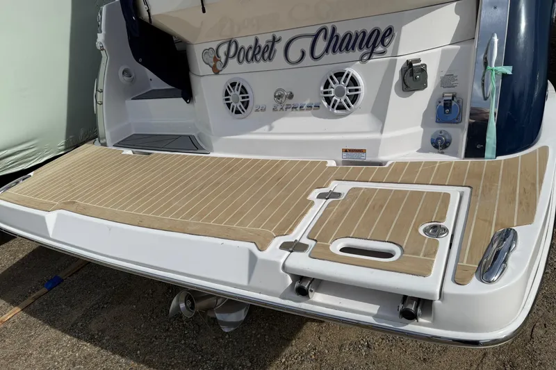 Slide: The Image of 2019 Regal 28 Express boat stern with teak swim platform and "Pocket Change" name. - 26