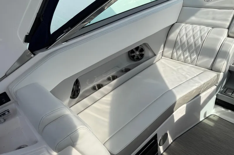 Slide: The Image of Luxurious seating area on a 2019 Regal 28 Express boat with cup holders and speakers. - 31