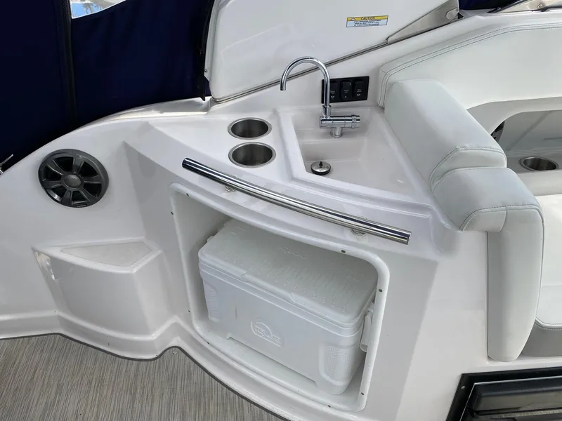 Slide: The Image of 2019 Regal 28 Express boat interior with sink, cup holders, and storage compartment. - 6
