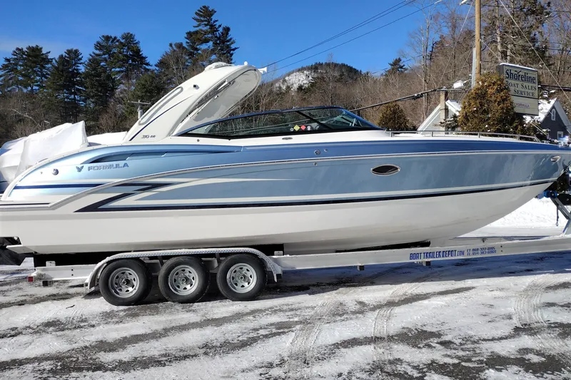The Image of 2026 Formula 310 Bowrider boat on trailer, snowy outdoor setting, trees in background. - 0