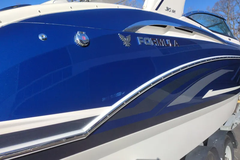 Slide: The Image of 2026 Formula 310 Bowrider boat rear view with dual propellers in snowy setting. - 10