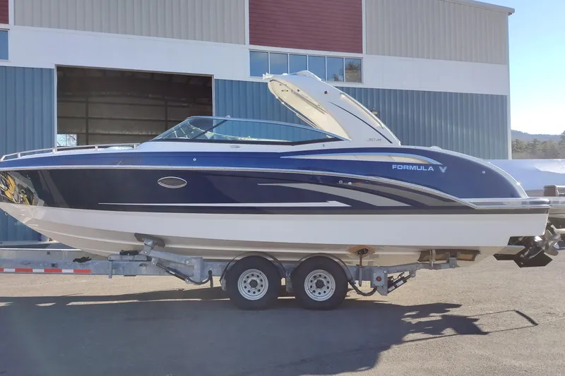 Slide: The Image of 2026 Formula 310 Bowrider boat on trailer, parked outdoors in snowy setting. - 2