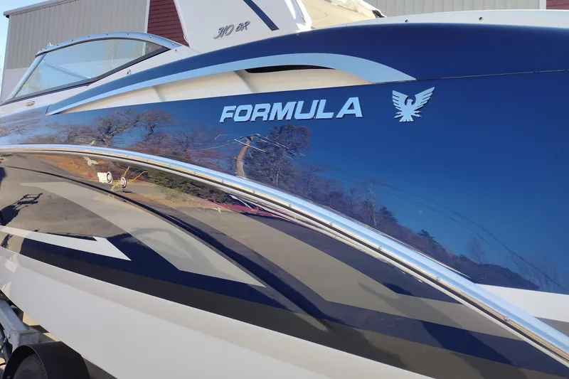 Slide: The Image of 2026 Formula 310 Bowrider boat with sleek blue and white design on a trailer. - 9