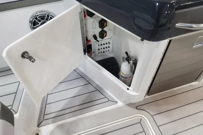 Slide: The Image of 2026 Formula 310 Bowrider interior storage compartment with safety equipment and controls. - 92