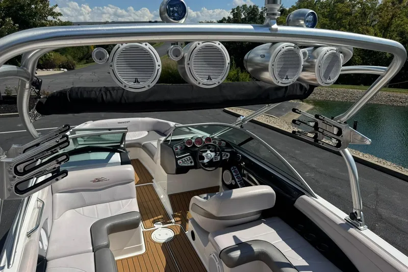 Slide: The Image of 2006 MasterCraft X-45 boat interior with speakers and seating, docked near a lake. - 14