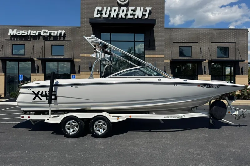 Slide: The Image of 2006 MasterCraft X-45 boat on trailer, parked outside dealership under clear sky. - 17